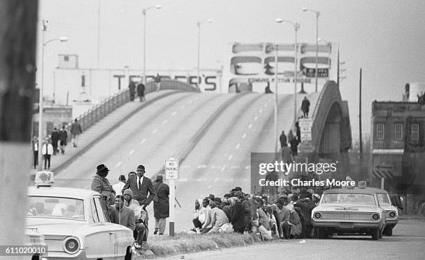 View of Civil Rights marchers on a median at the base of the Edmund Pettus Bridge during the first Selma to Montgomery March, Selma, Alabama, March...