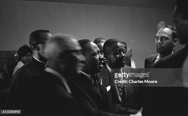 American Civil Rights leaders Dr Martin Luther King Jr and Ralph Abernathy speak with unidentified others at Medgar Evers' funeral, Jackson,...