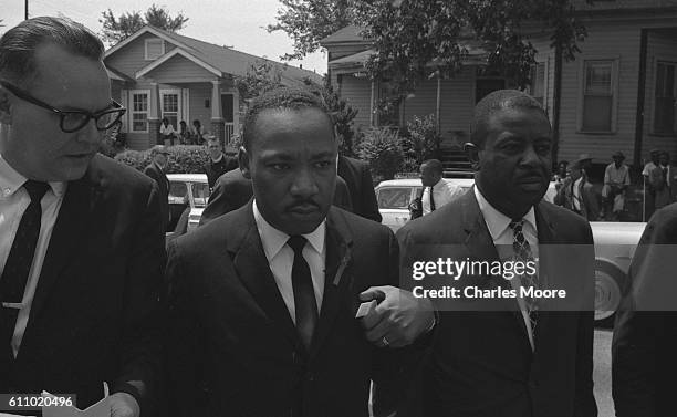 American Civil Rights leaders Dr Martin Luther King Jr and Ralph Abernathy speak with a unidentified man during Medgar Evers' funeral procession,...