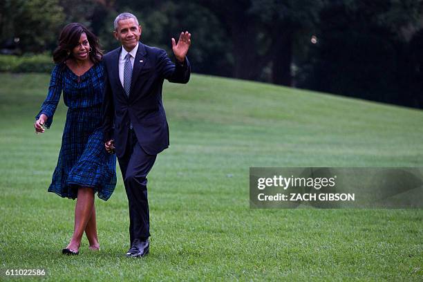 President Barack Obama and US First Lady Michelle Obama walk on the South Lawn after arriving at The White House on September 28, 2016 in Washington,...