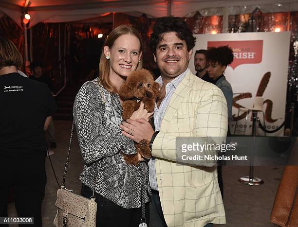 Liz Bresler and Alex Bresler pose with Chase the dog during the celebration of the launch of Rachael Ray's Nutrish DISH with a Puppy Party on...