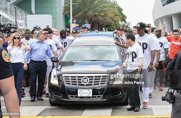 Miami Marlins owner, Jeffrey Loria, along with players and other members of the Marlins organization and their fans gather next to the hearse...