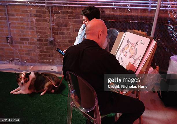 Dog and their owner participate in a caricature drawing during the celebration of the launch of Rachael Ray's Nutrish DISH with a Puppy Party on...
