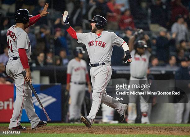 Dustin Pedroia of the Boston Red Sox celebrates with Marco Hernandez after scoring against the New York Yankees in the eighth inning at Yankee...