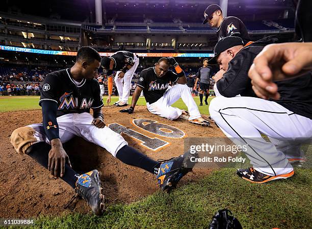 Dee Gordon, Marcell Ozuna, Martin Prado, Marcell Ozuna, and Miguel Rojas of the Miami Marlins gather around the pitching mound after the game against...