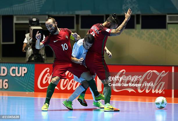 Cristian Borruto of Argentina battles with Ricardinho of Portugal and Joao Matos of Portugal during the FIFA Futsal World Cup semi-final match...