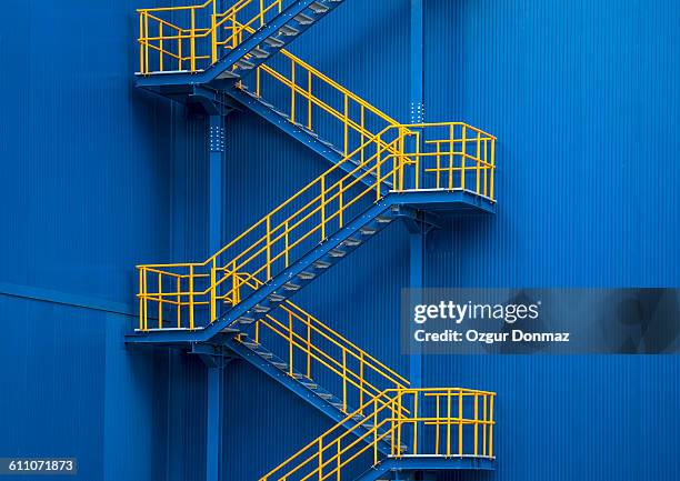 yellow metal staircase against a blue wal - outdoor metal stairs stock pictures, royalty-free photos & images