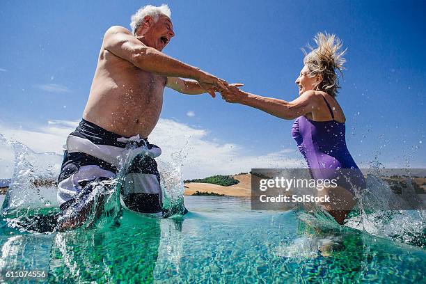 senior paar machen einen großen spritzer in italien! - old couple jumping stock-fotos und bilder