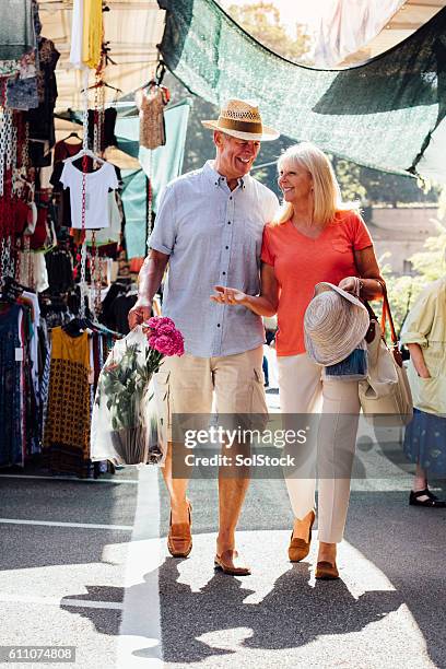 senior couple vistiting an outdoor market - tourist market stockfoto's en -beelden