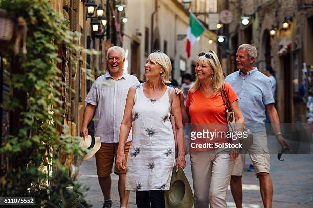 coppie mature che si guardano intorno al centro storico italia - tourist group foto e immagini stock