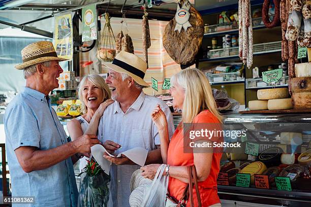 mature couples shopping in an italian delicatessen - seniors shopping stock pictures, royalty-free photos & images