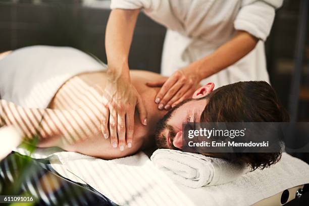 man having back massage at the health spa. - beauty spa stockfoto's en -beelden