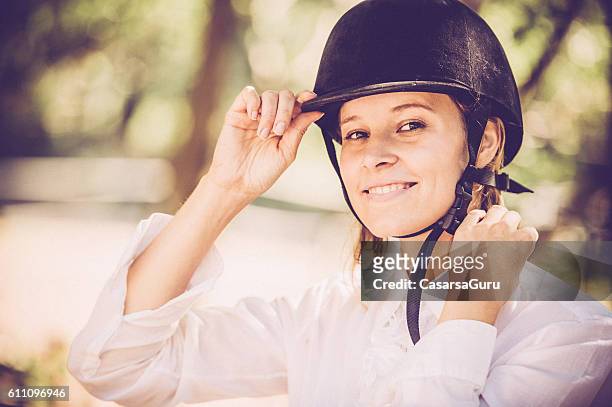 mujer joven que consigue leer para un horseriding - riding hat fotografías e imágenes de stock