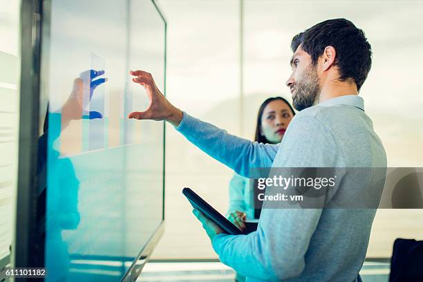 colleagues talking in front of a screen with a graph - financial analyst 個照片及圖片檔