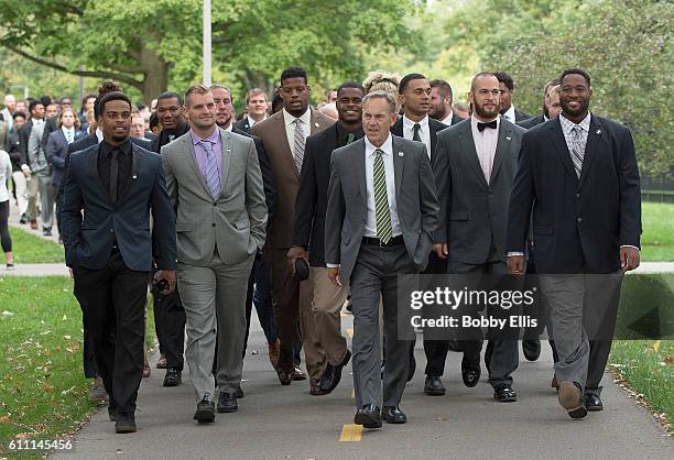 Head coach Mark Dantonio of the Michigan State Spartans and members of the team walk to Spartan Stadium before the start of the game against the...