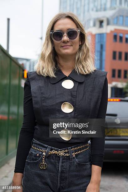 Fashion blogger Anne-Laure Mais wears a Opening Ceremony top, vintage Levis jeans, vintage bag and glasses on day 3 of London Womens Fashion Week...