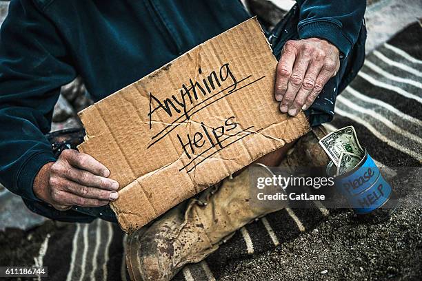 hombre sin hogar con lata de dinero pidiendo dinero - limosna fotografías e imágenes de stock