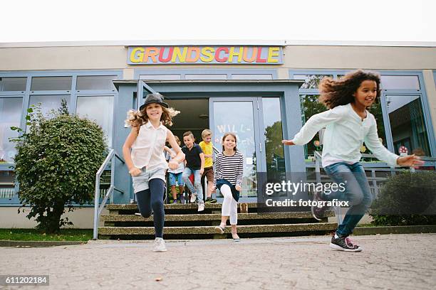 grundschüler laufen die schule zum schulhof - kind im grundschulalter stock-fotos und bilder