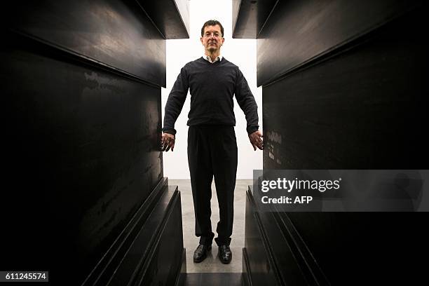 British artist Antony Gormley poses for a photograph with one of his works titled "Passage", part if his Fit exhibit, at White Cube, Bermondsey in...