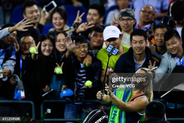 Dominika Cibulkova of Slovakia takes a selfie with fans after winning the women's singles third round match against Karolina Pliskova of the Czech...