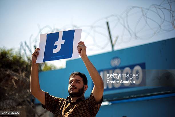 Palestinian demonstrator holds a banner during a protest against blocking of Facebook to Palestinian's accounts in front of the Office of United...