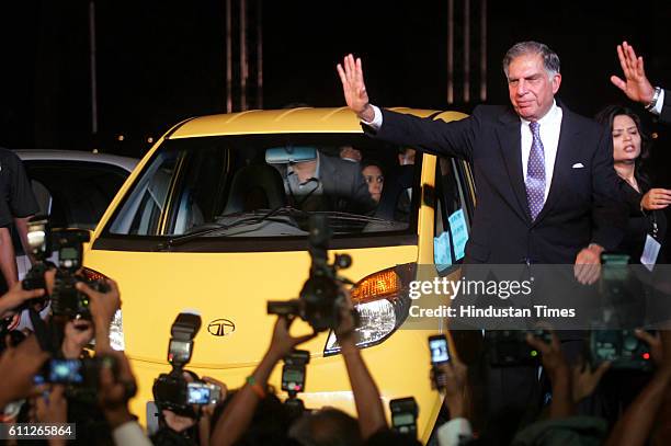 Tata Sons Chairman - Ratan Tata poses alongside the Tata Nano at its launch in Mumbai on Monday.
