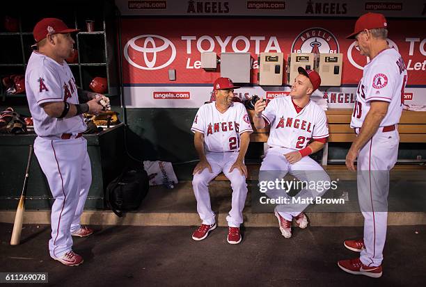 Kole Calhoun, bench coach Dino Ebel, Mike Trout and third base coach Ron Roenicke of the Los Angeles Angels of Anaheim joke around before the game...
