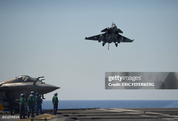 This picture taken on September 29 shows a Rafale Marine combat aircraft shipboarding the French aircraft carrier Charles de Gaulle as it sails in...