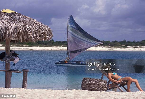 Young sensual woman relax beside lagoon at Jericoacoara beach in Ceara State, Brazil - jangada .