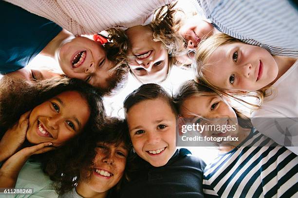 laughing group of kids in circle - child and unusual angle stockfoto's en -beelden