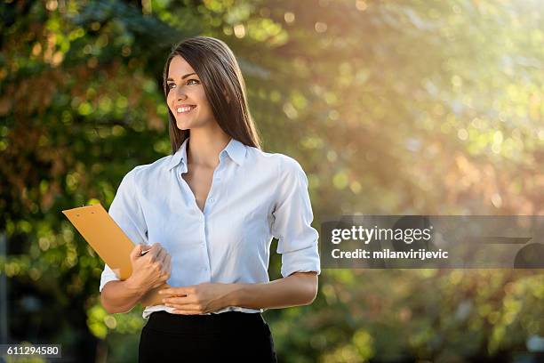beautiful young businesswoman in the park - polite girl stock pictures, royalty-free photos & images