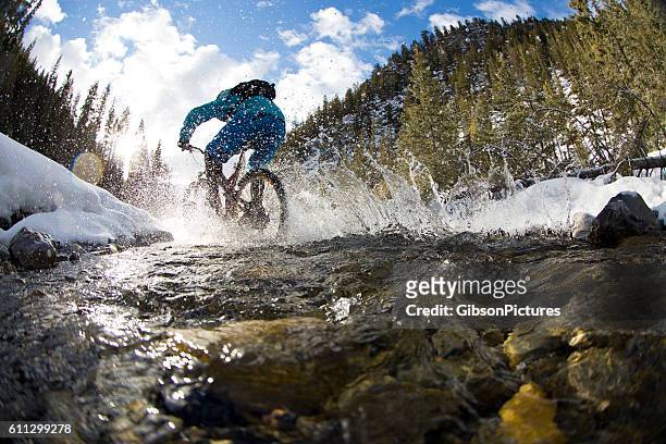 winter mountain bike creek crossing - mountainbiken fietsen stockfoto's en -beelden