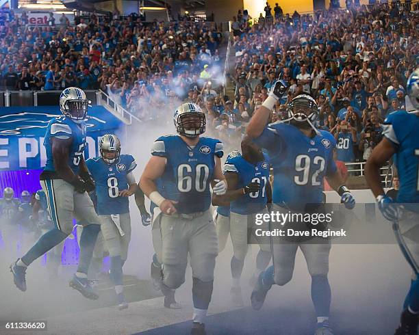 Haloti Ngata and Graham Glasgow of the Detroit Lions run onto the field to start the NFL game against the Tennessee Titans at Ford Field on September...