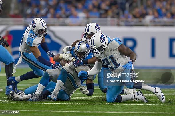 Theo Riddick of the Detroit Lions is tackled by Avery Williamson and Da'Norris Searcy the Tennessee Titans during an NFL game at Ford Field on...
