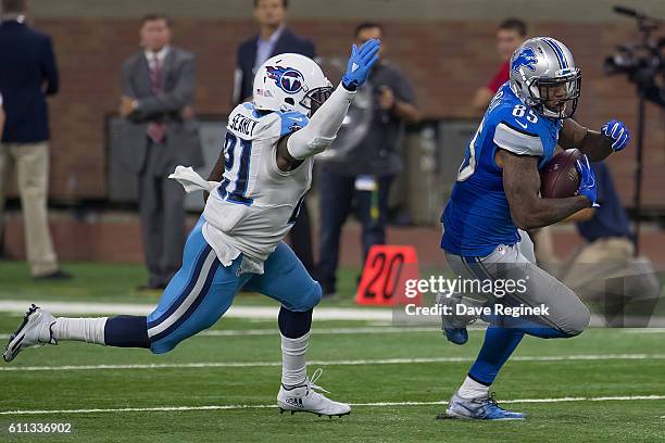 Eric Ebron of the Detroit Lions runs with the football in front of Da'Norris Searcy of the Tennessee Titans during an NFL game at Ford Field on...