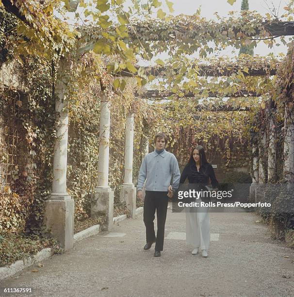 Argentine born actress Olivia Hussey and English actor Leonard Whiting pictured together walking under a vine covered pergola in Verona, Italy in...