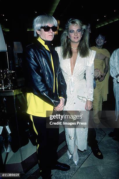 Andy Warhol and Cornelia Guest attend a perfume launch at Macy's circa 1985 in New York City.