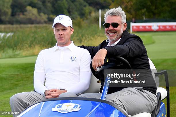 Captain Darren Clarke of Europe drives Danny Willett in a cart during practice prior to the 2016 Ryder Cup at Hazeltine National Golf Club on...