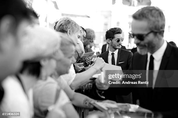 Pierre Niney and Jerome Salle write autographs and take selfies as they attends the 'L'Odyssee' premiere during the 12th Zurich Film Festival on...