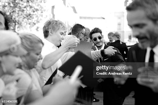 Pierre Niney and Jerome Salle write autographs and take selfies as they attends the 'L'Odyssee' premiere during the 12th Zurich Film Festival on...