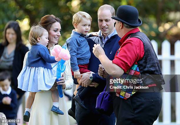 Catherine, Duchess of Cambridge holding Princess Charlotte of Cambridge and Prince George of Cambridge, being held by Prince William, Duke of...