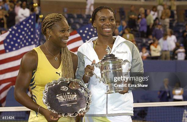 Venus Williams and her sister Serena hold their trophies during the awards presentation in the women's final match of the US Open at the USTA...
