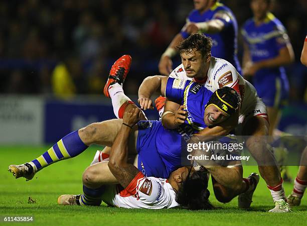 Chris Hill of Warrington Wolves is tackled by Jon Wilkin and Atelea Vea of St Helens during the First Utility Super League Semi Final match between...