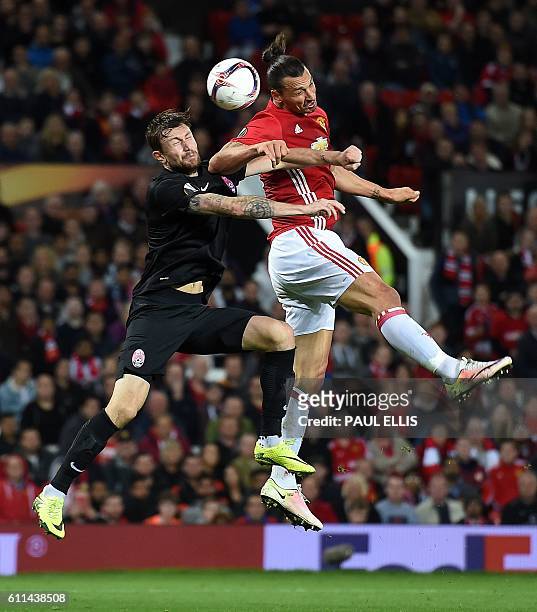 Manchester United's Swedish striker Zlatan Ibrahimovic vies in the air with Zorya's Belarusian defender Mikhail Sivakov as he heads the ball towards...