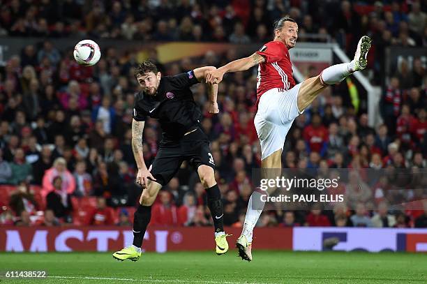 Manchester United's Swedish striker Zlatan Ibrahimovic vies in the air with Zorya's Belarusian defender Mikhail Sivakov as he heads the ball towards...