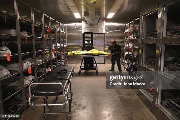 Death investigator Trevis Hairston moves a corpse in the morgue of the Pima County Medical Examiner on September 29, 2016 in Tucson, Arizona....