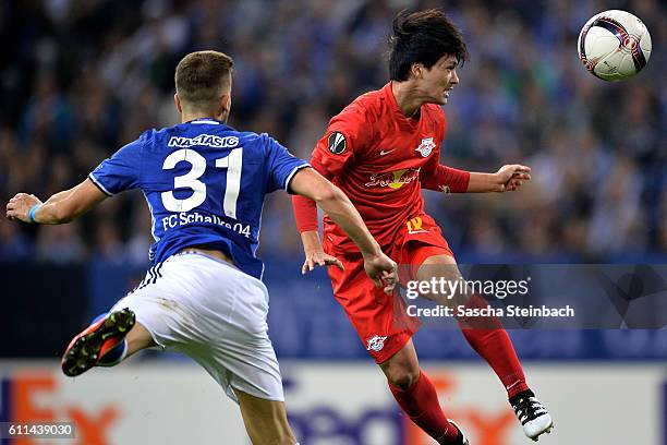 Matija Nastasic of Schalke and Takumo Minamino of Salzburg jump for a header during the UEFA Europa League match between FC Schalke 04 and FC...