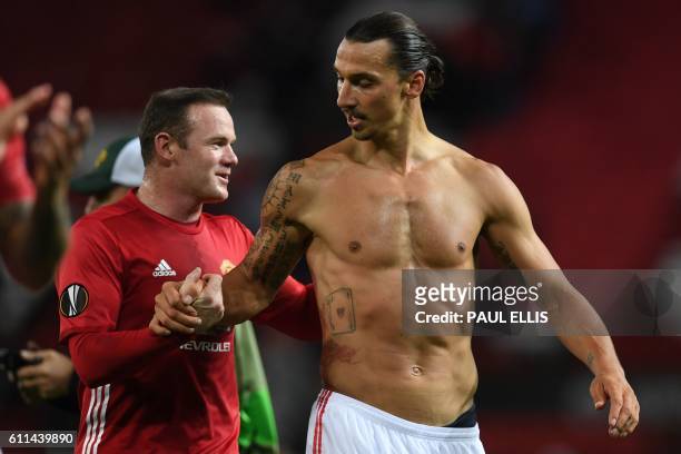 Manchester United's Swedish striker Zlatan Ibrahimovic and Manchester United's English striker Wayne Rooney applaud the fans following the UEFA...