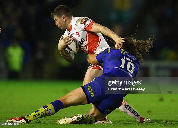 Mark Percival of St Helens is tackled by Ashton Sims of Warrington Wolves during the First Utility Super League Semi Final match between Warrington...