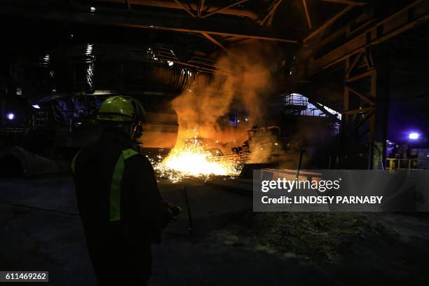 Steelworker watches as molten steel pours from one of the Blast Furnaces during 'tapping' at the British Steel - Scunthorpe plant in north...